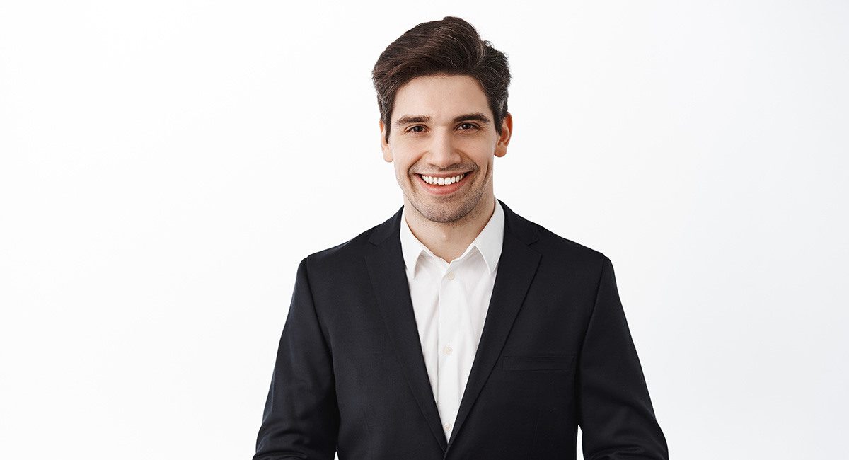 Handsome corporate man real estate agent assistant smiling hold hands together how may i help you smiling friendly polite assist customer white background web